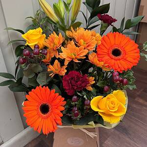 Autumn flower box with orange gerberas, yellow roses, orange chrysanthemums and lilies